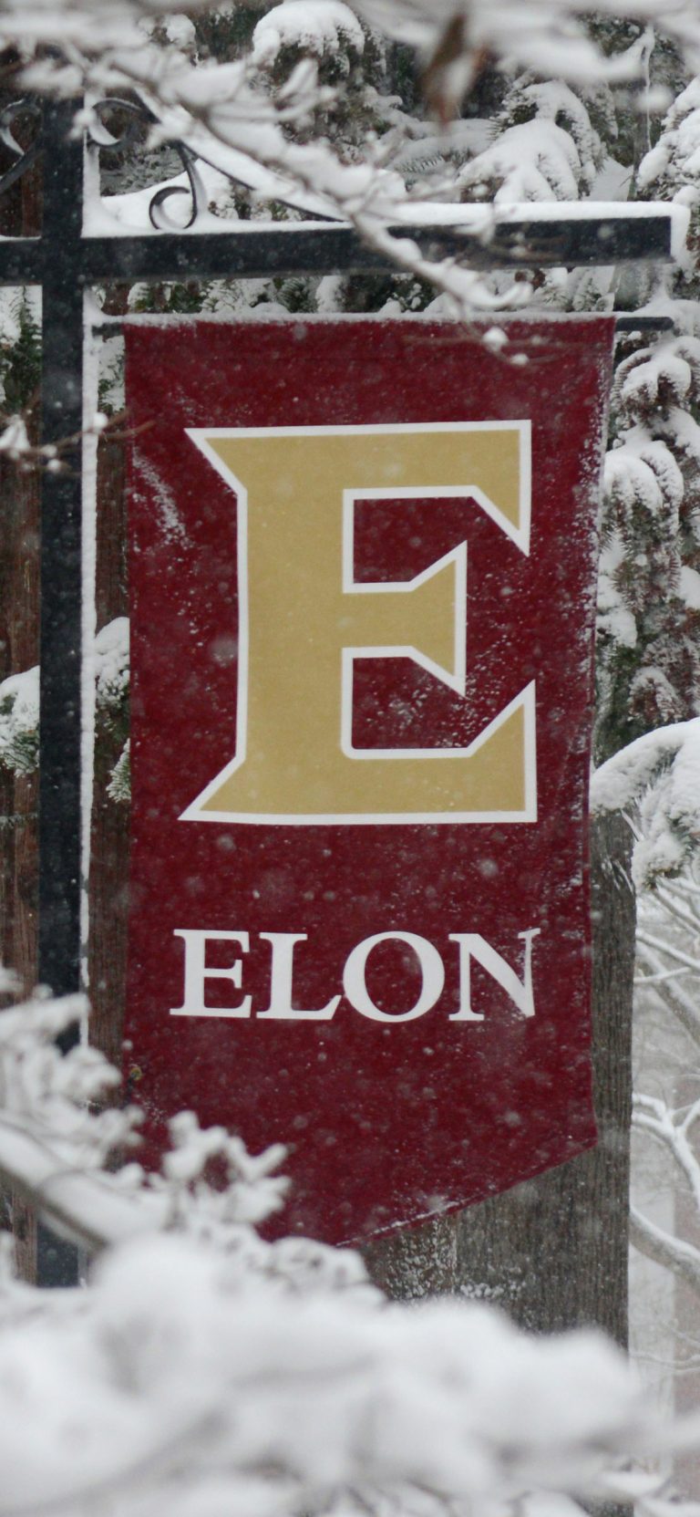 Elon University banner covered in snow.