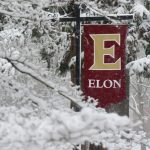 Elon University banner covered in snow.
