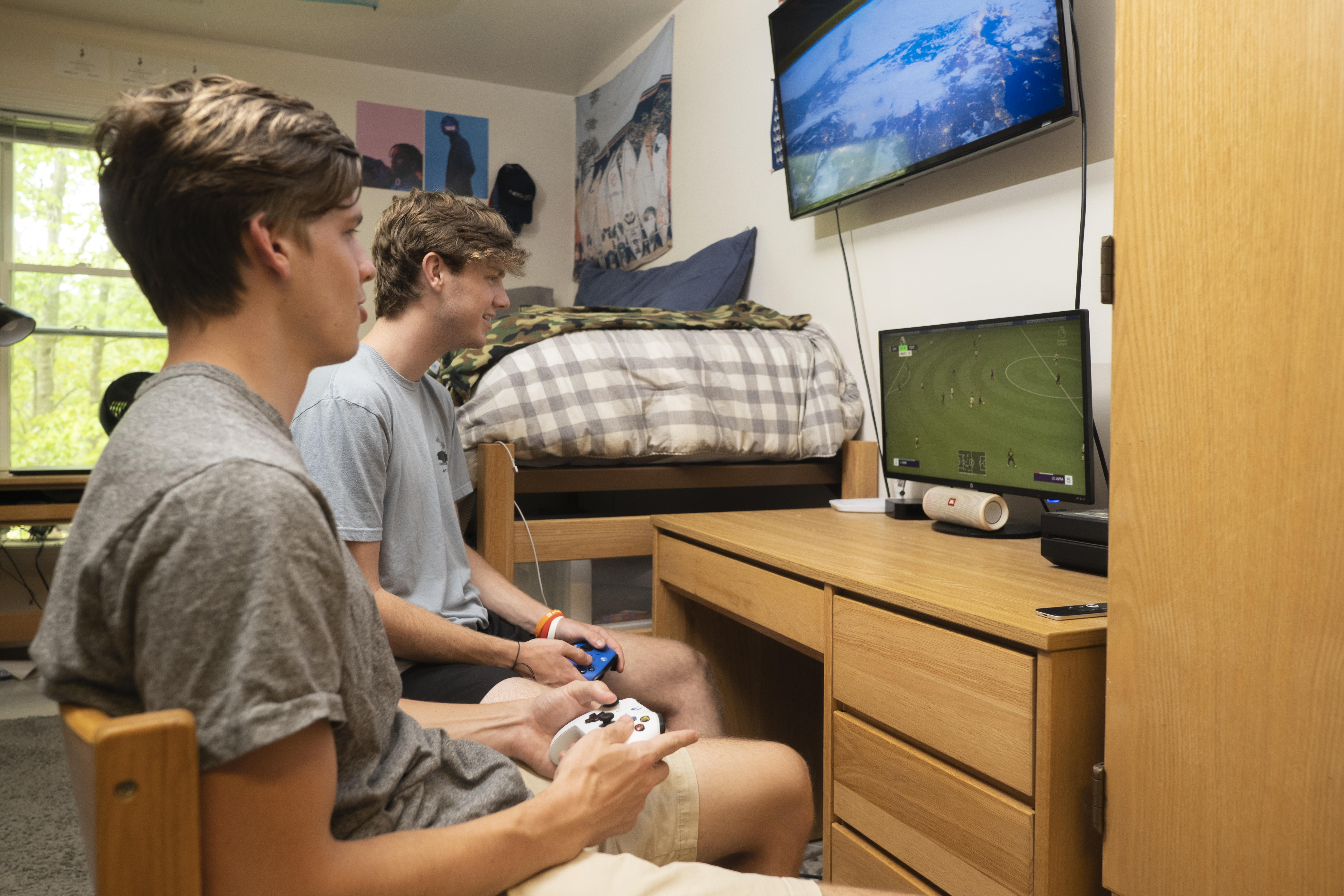 Two guys playing video games at a computer in their room at Loy Center.