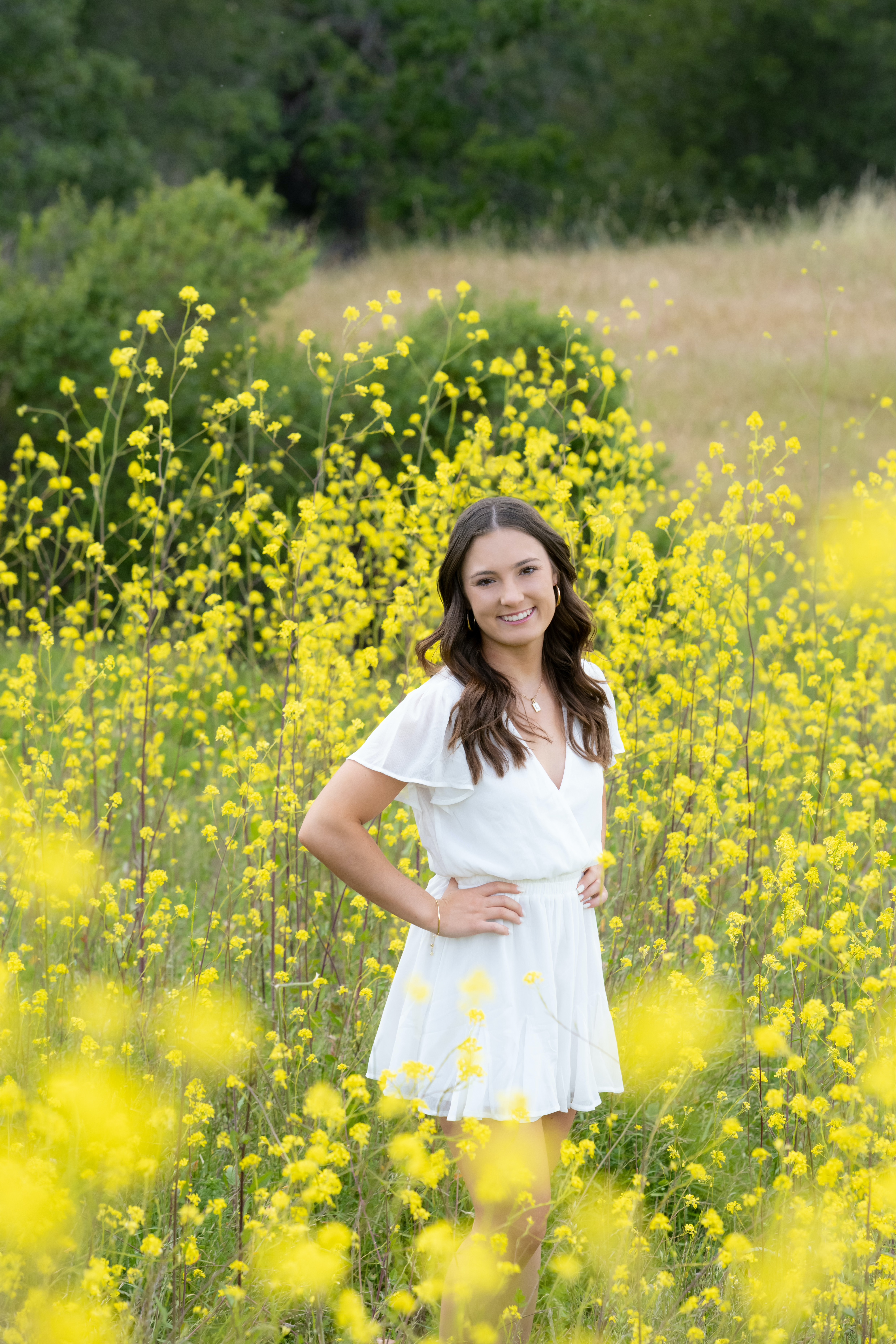 Lucy McAfee poses in a field of yellow wild flowers