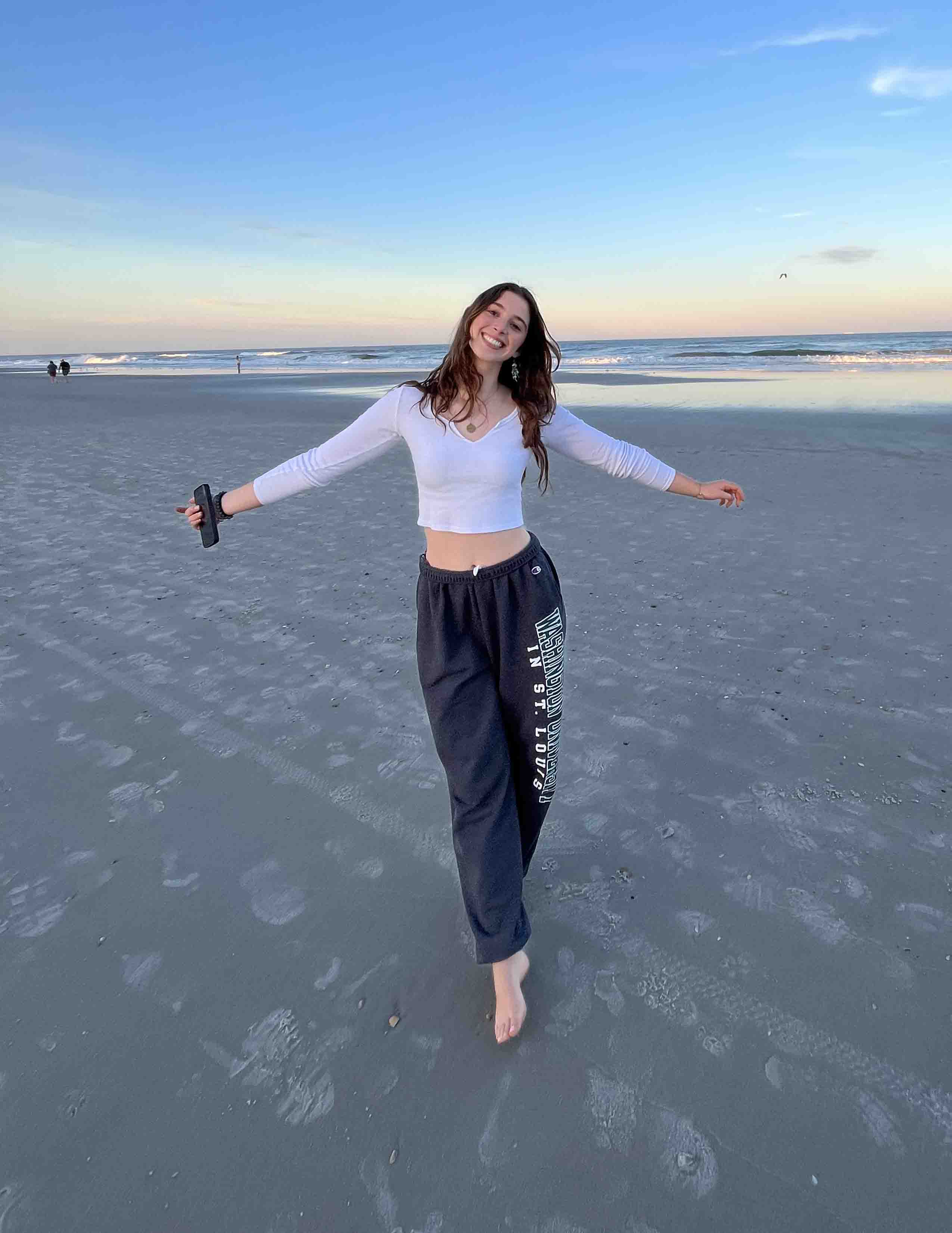 Olivia Rosen posing on the beach with the ocean behind her.