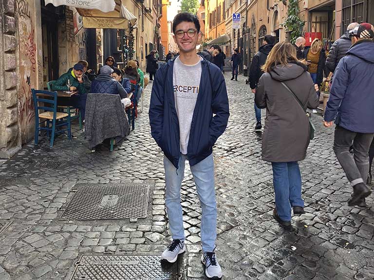 An Elon student stands on a cobblestone street in Rome during a study abroad experience.