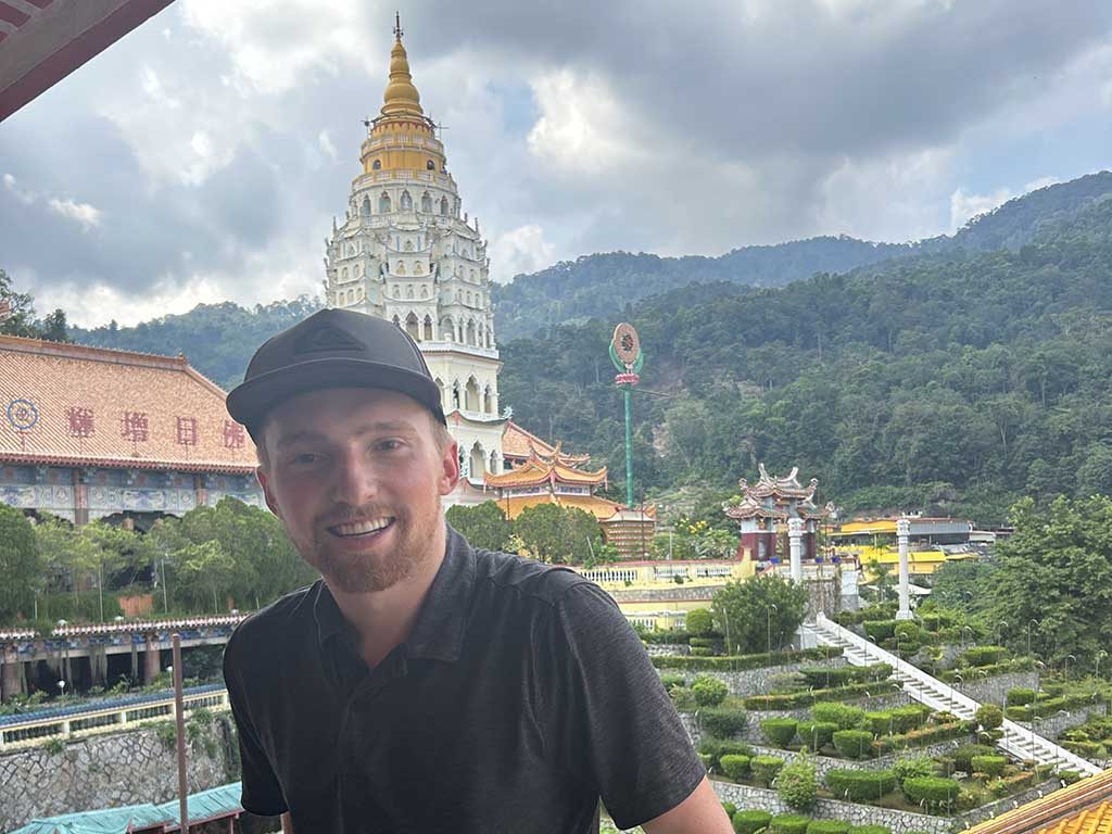 An Elon students stands with Ban Po Tha Pagoda 10000 Buddhas, Kek Lok Si Temple complex, behind him during time in Penang, Malaysia.