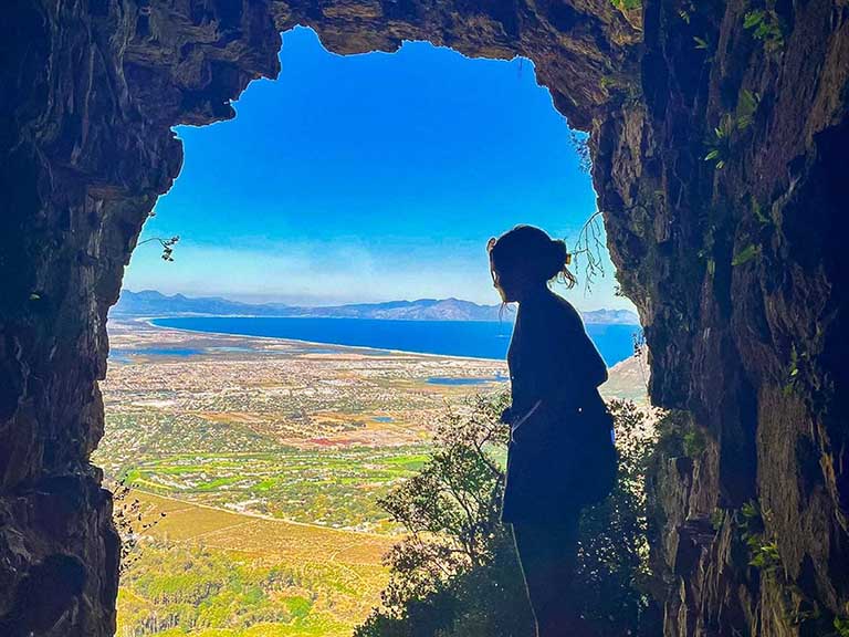 An Elon student in Elephant's Eye Cave in Cape Town, South Africa, during a study abroad experience.