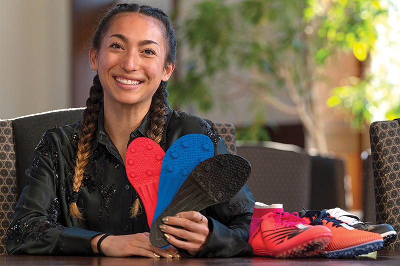 Madison George shows some of the designs for women’s pole vault shoes that she designed and printed on a 3-D printer at ϲ. The student-athlete's undergraduate research at Elon has garnered attention from Nike and Adidas.
