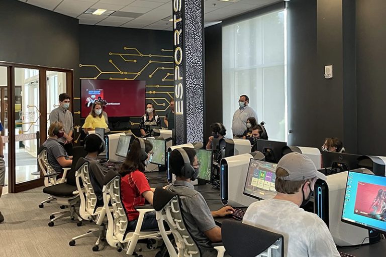Students are wearing headsets and staring a computers in the Esports room.