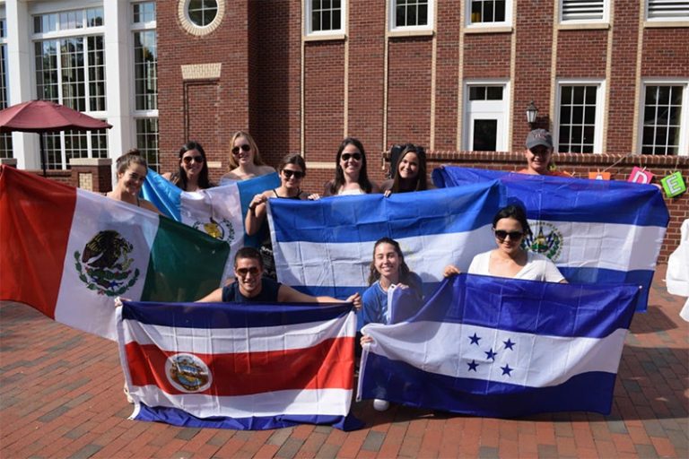 Students hold up different Latinx/Hispanic flags.