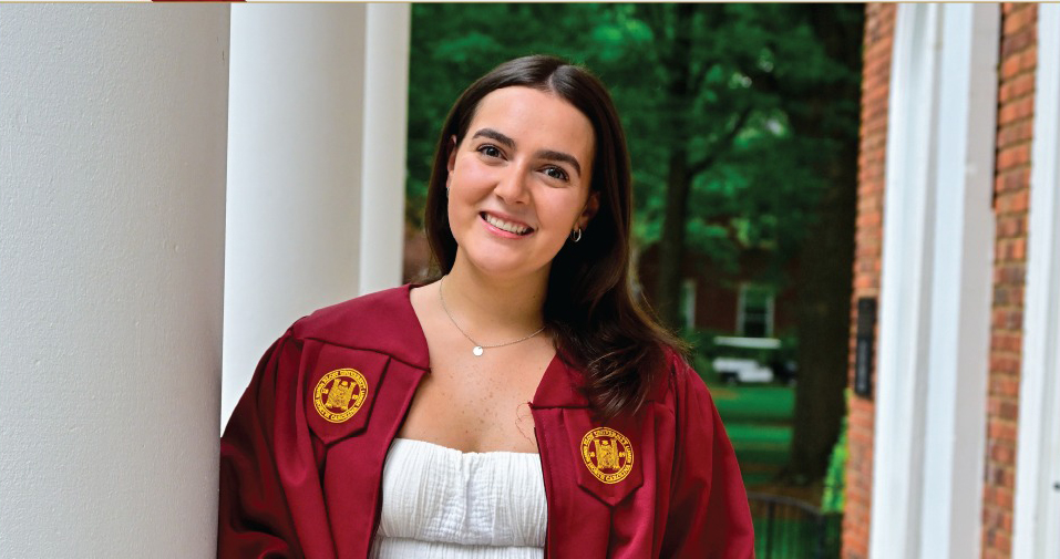 Portrait photo of Emma Doherty wearing her graduation gown and holding her cap