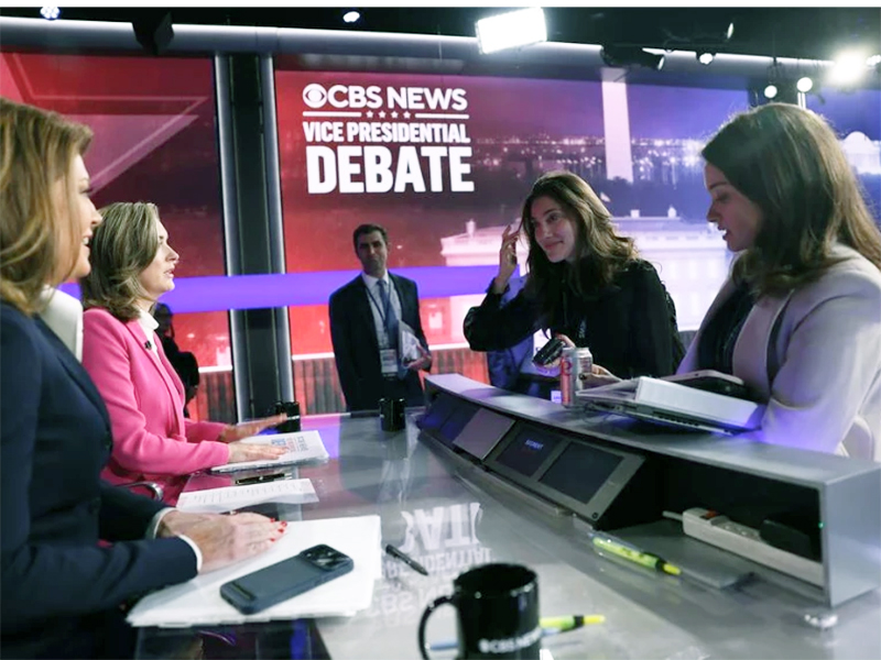 Elon alumna Julie Morse, a senior producer at CBS, consults with others on the set of a vice presidential debate.