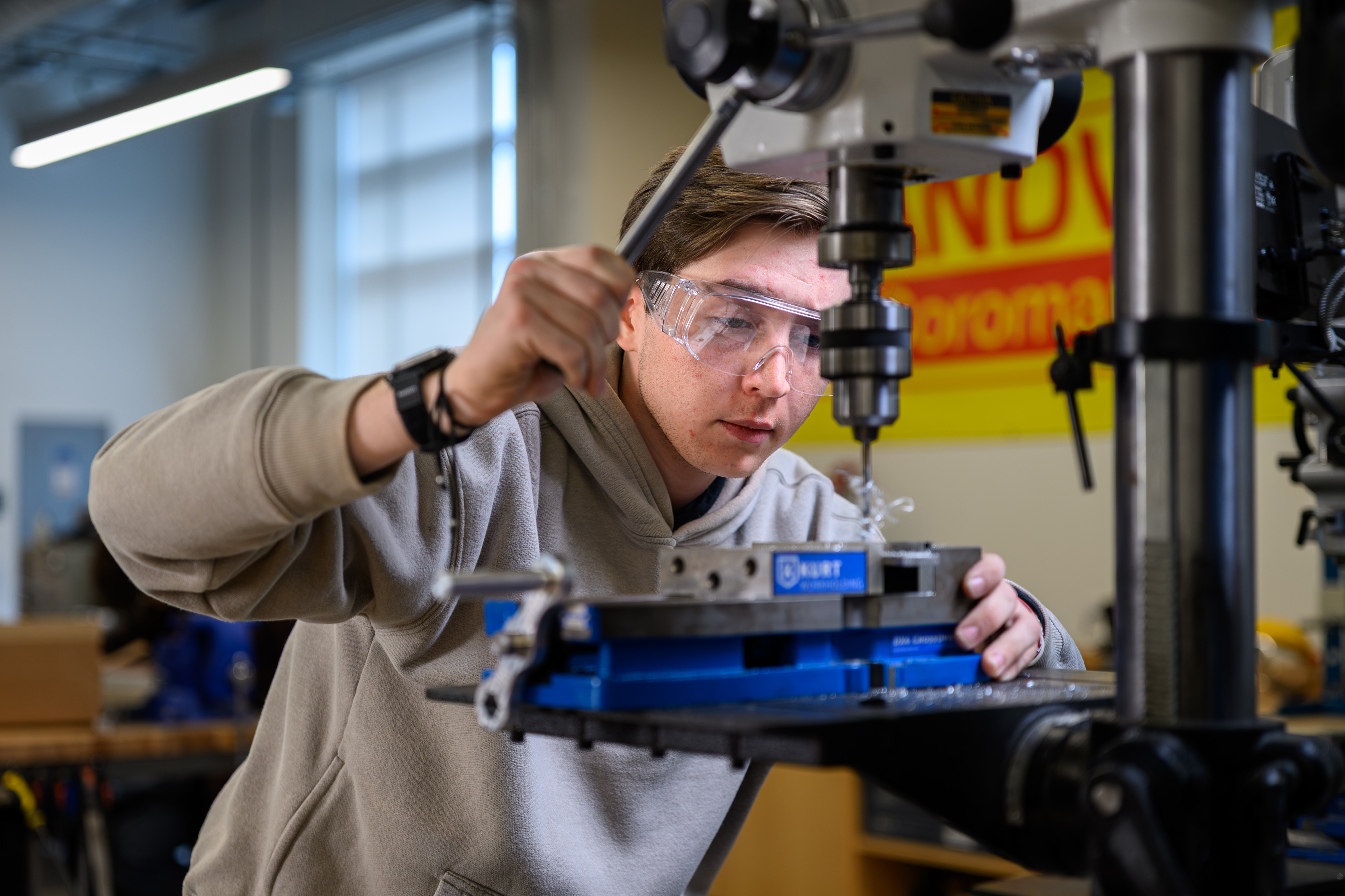 A student wearing goggles uses equipment in the Innovation Lab.