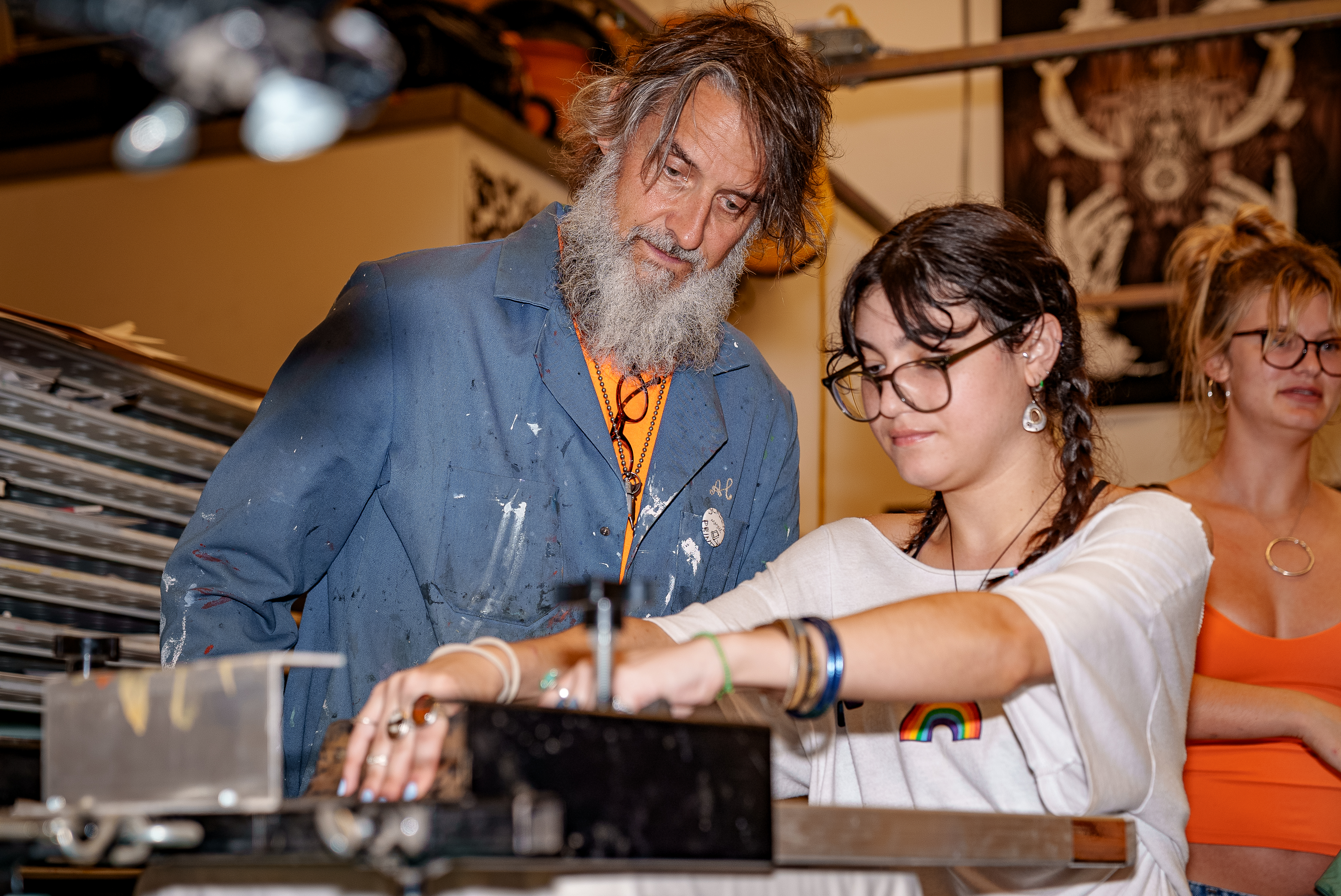 An art professors works with a student on an art project.