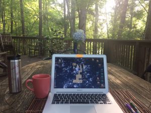 Writing on a laptop at the Writing Residency Tree House location 