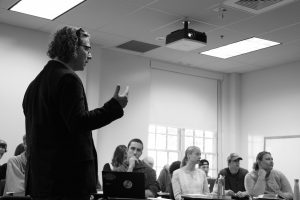 Professor lecturing to students in a classroom. 