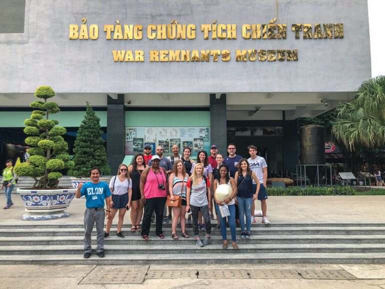 a group picture of Elon MBA program students in front of a war musuem in Vitenam