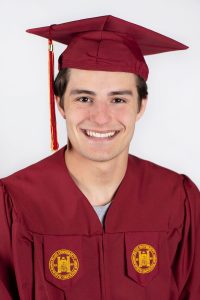 A male college graduate wearing a maroon cap and gown