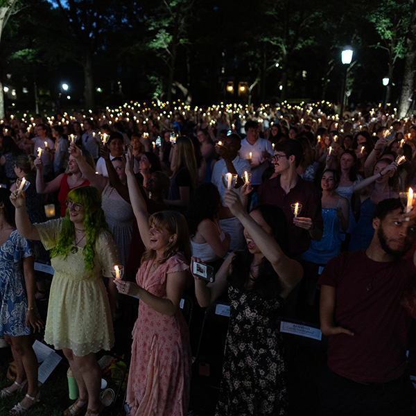 A group of students holding lit candles at night