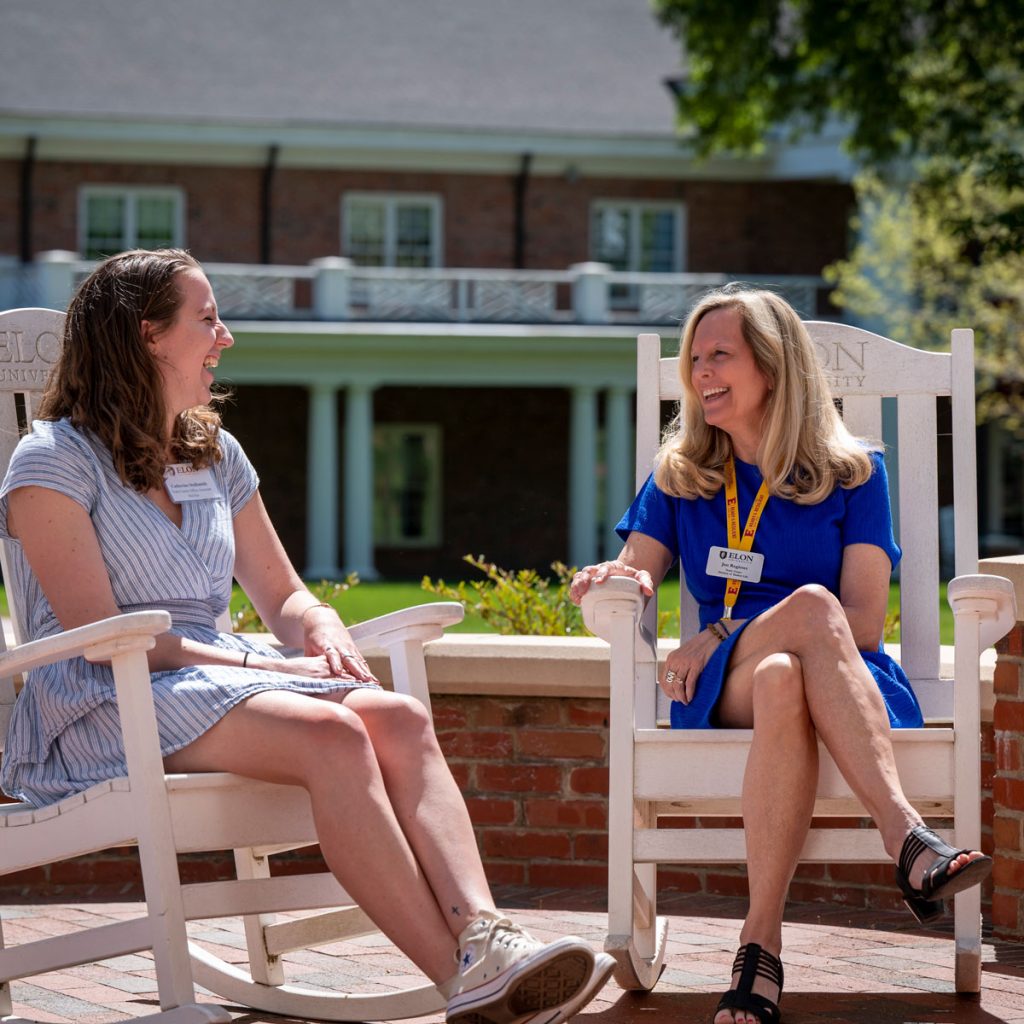 Catherine Stallsmith and her mentor, Jan Register, sitting in white rocking chairs on a brick patio.