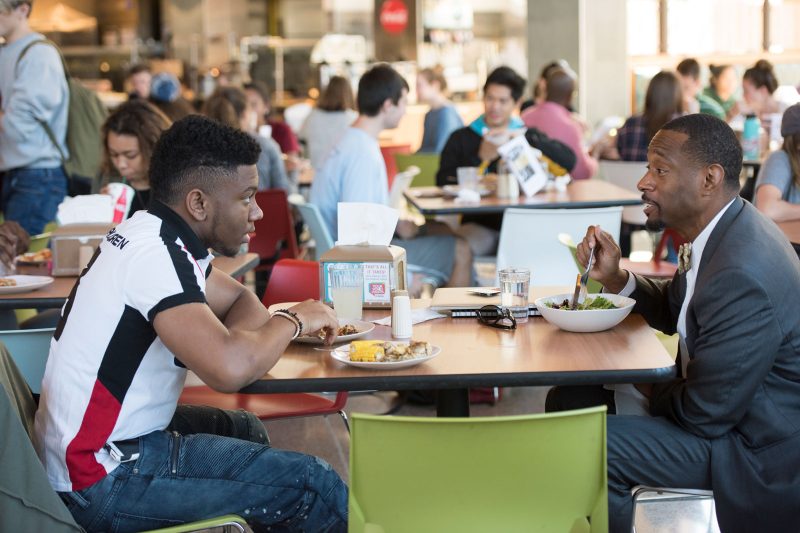 An Elon mentor and their mentee sitting at a table in a cafeteria having lunch.