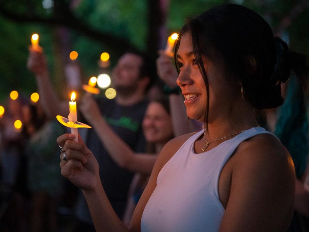 A student holds up a candle during Elon's Senior Baccalaureate Reflection ceremony.