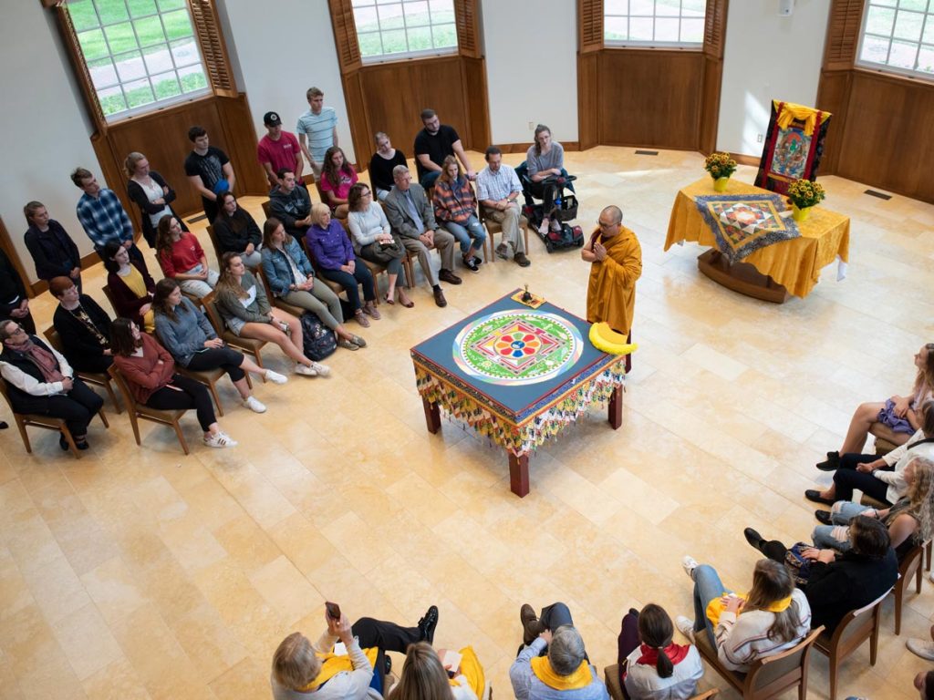 Faculty, staff and students participate in a ceremony with Tibetan Buddhist monks after the completion of a sand mandala.