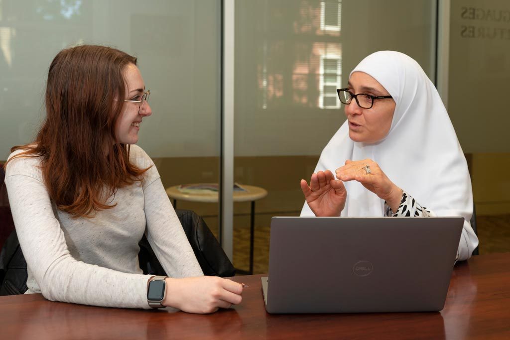 Shereen Elgamal, lecturer in Arabic and Middle Eastern Studies, sits at a conference room table with a mentee.