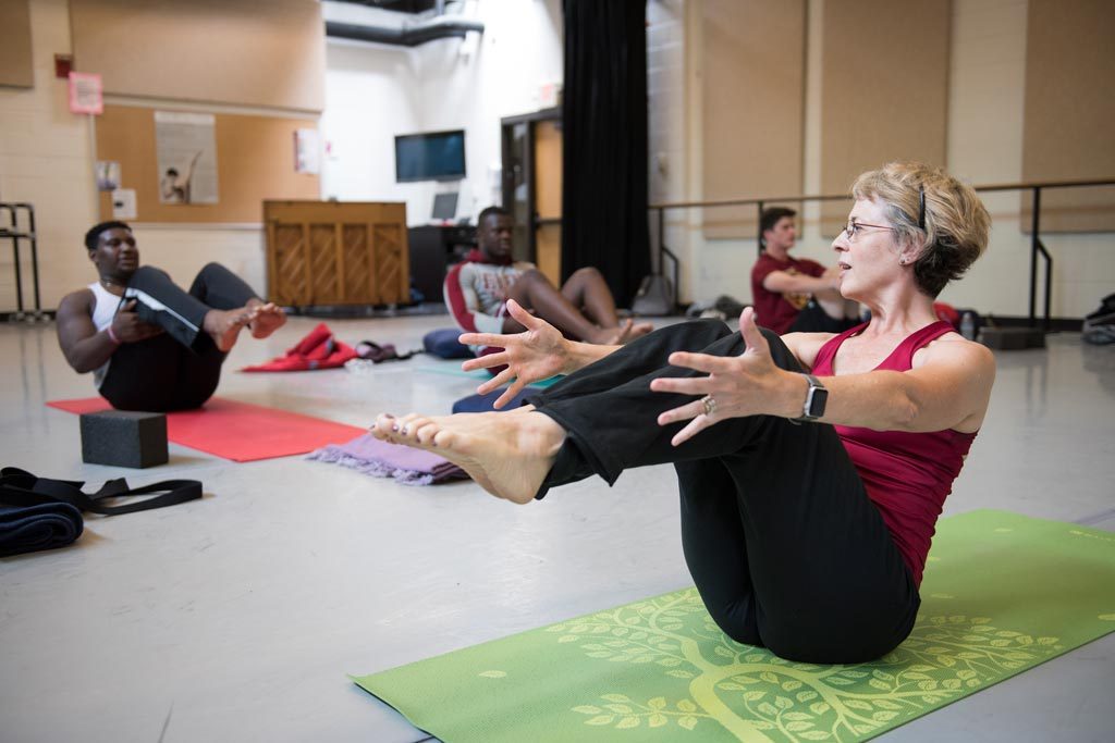 Professor of Dance Lauren Kearns works with students in her summer yoga class in the Center for the Arts.