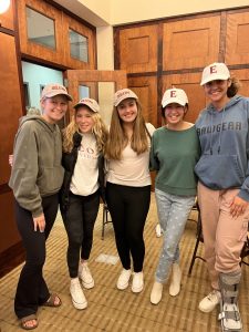 group of 5 female students wearing Elon hats