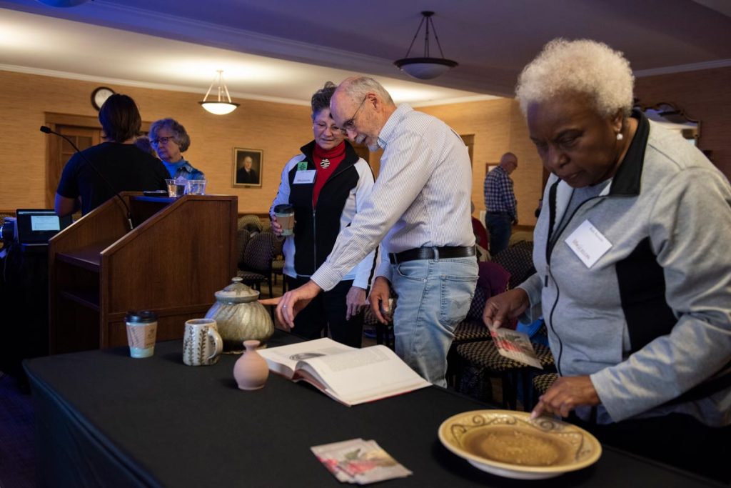 Older adults interacting with a pottery presentation during a Life at Elon class.