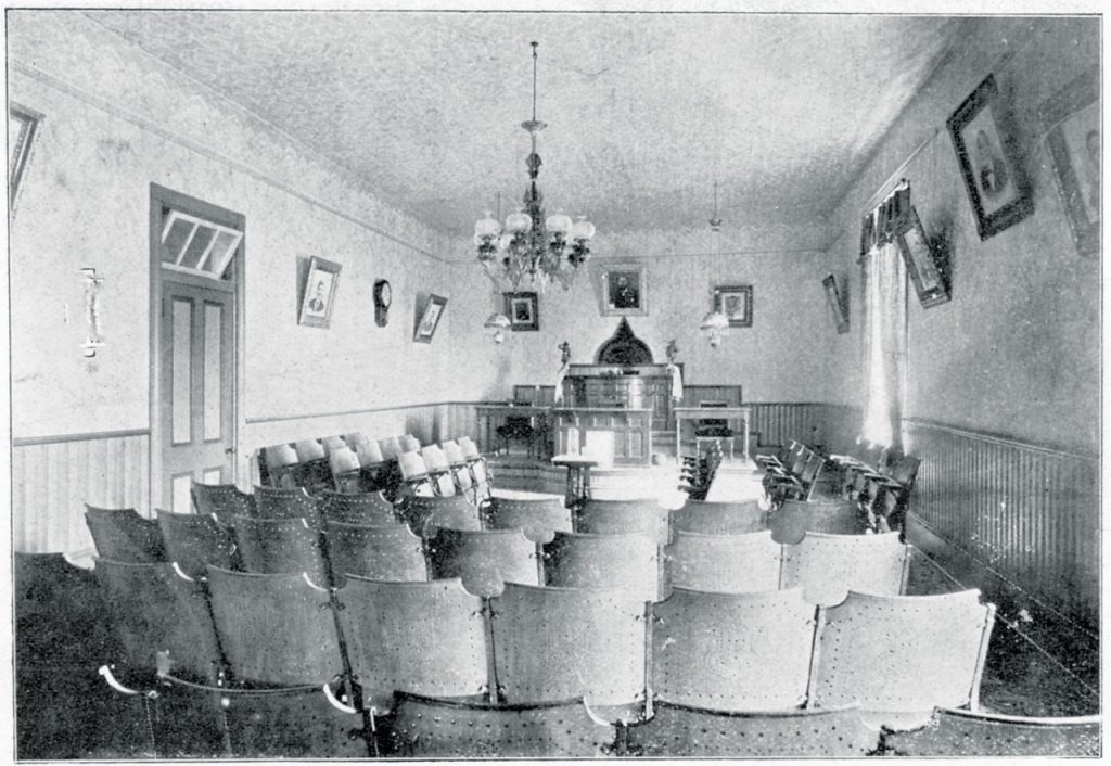 Black and white scan of a historic photograph of the chandlier that hung in Philologian Literary Society Hall in the main administration building circa 1901.