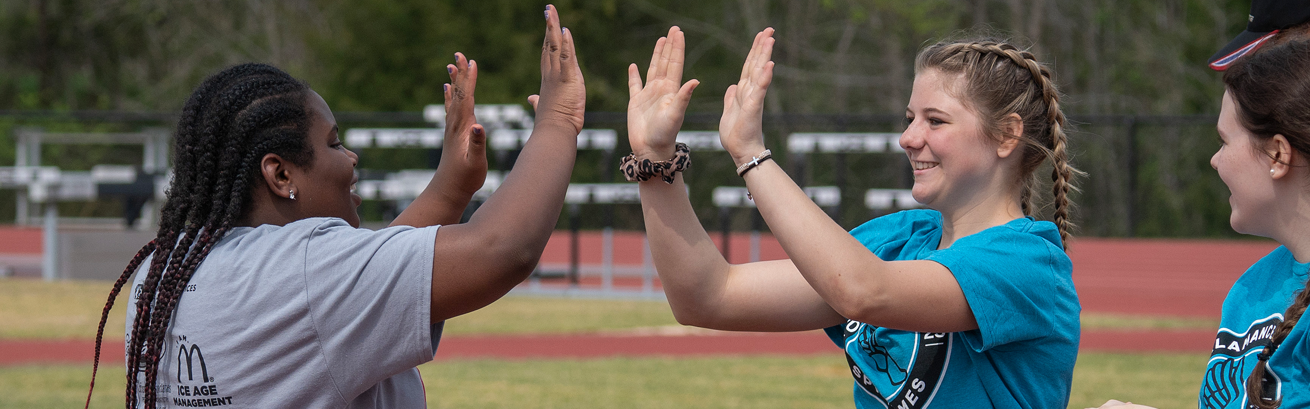 A volunteer congratulates an athlete after a running event at the 2023 Alamance County Spring Games Special Olympics, April 6, 2023.