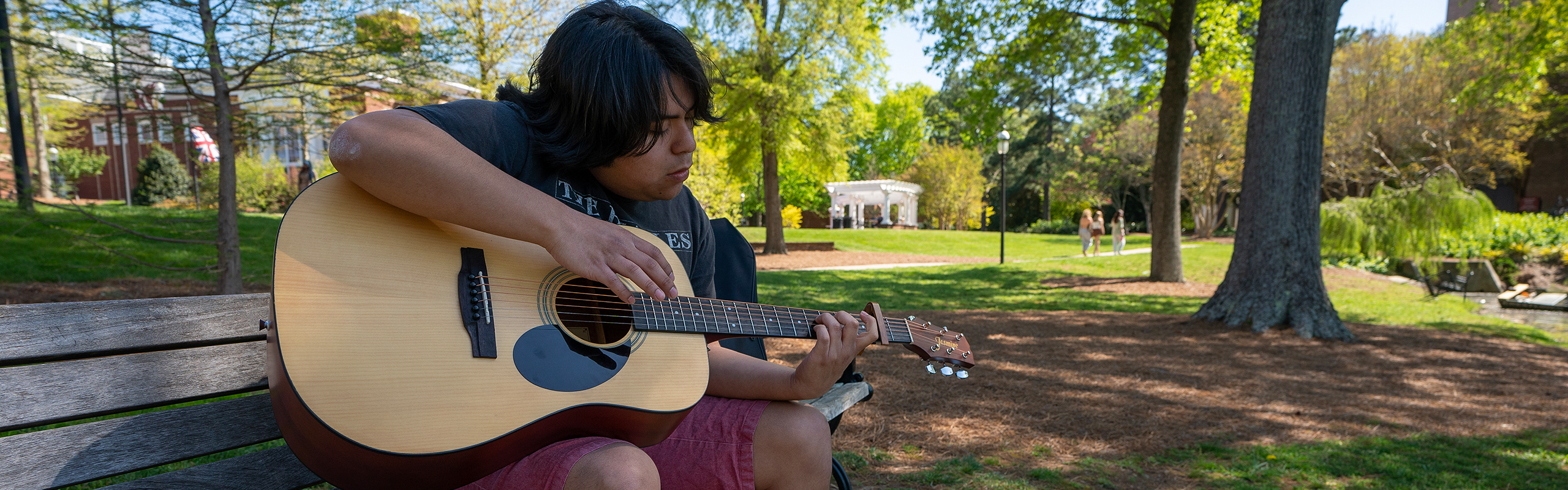 Jake Levin ’24, plays guitar by Lake Mary Nell, April 11, 2023.