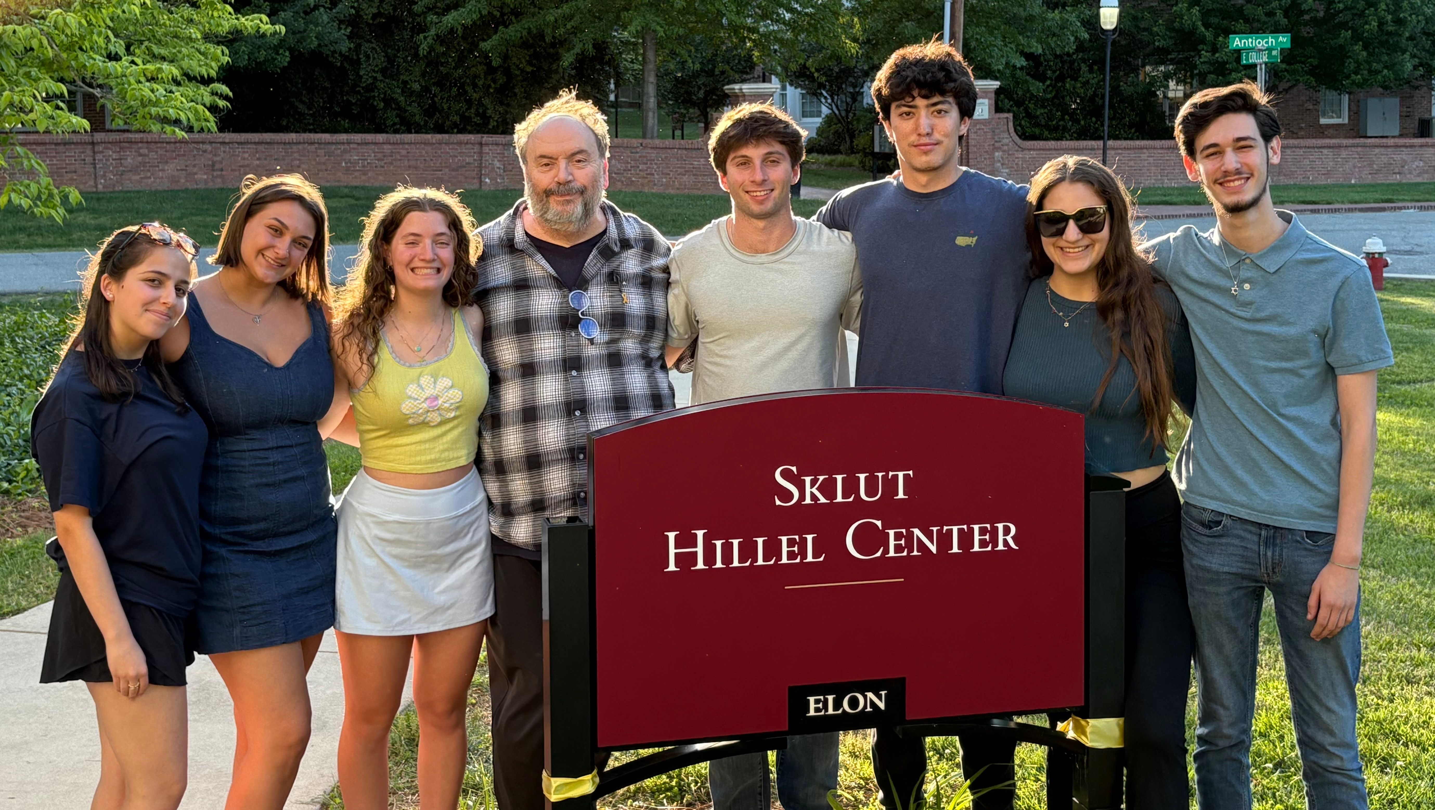 Student leaders standing next to the Sklut Hillel Center sign.