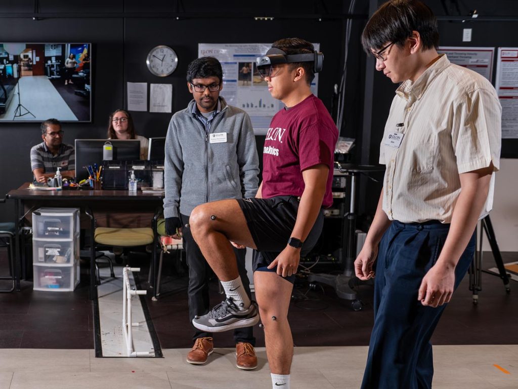 Assistant Professor of Computer Science Pratheep Paranthaman observes a subject, wearing a virtual reality headset, as they navigate the Elon Health Sciences lab.