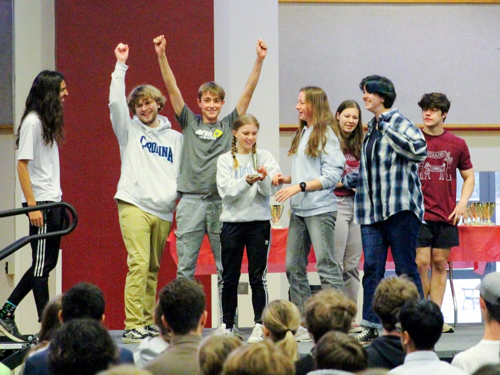 A high school team jubilantly celebrates their first-prize win on stage in Alumni Gym during N.C. German Day at Elon University.