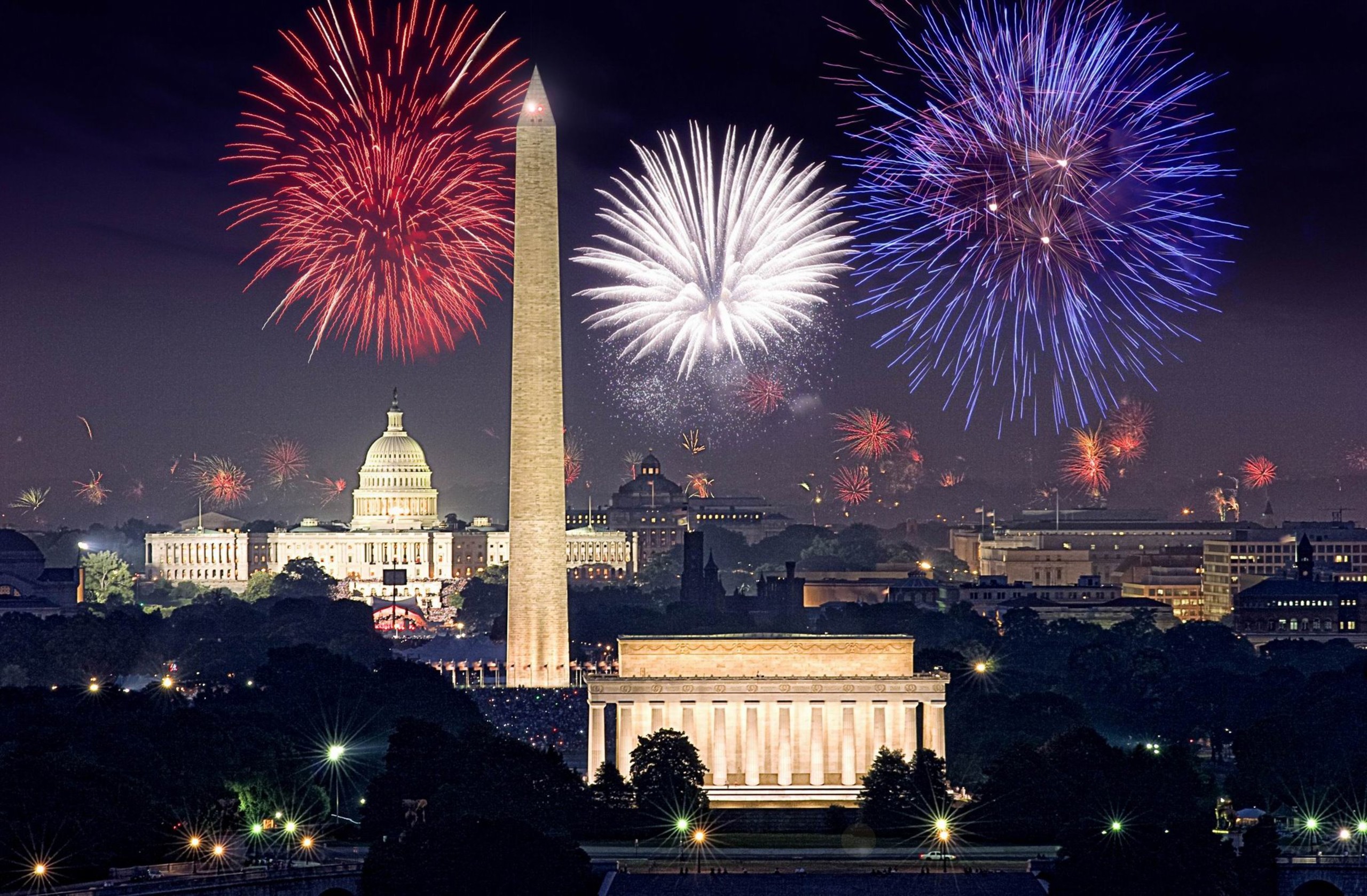 Red, white, and blue fireworks going off above DC