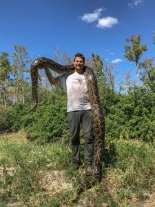 Ian Easterling '14 holds a very large python on his shoulders.