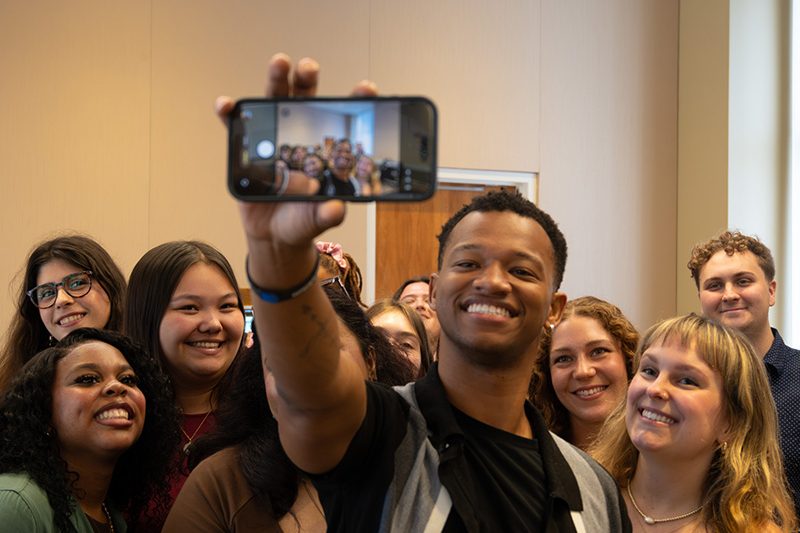 A photo of new MHE program students taking a group selfie