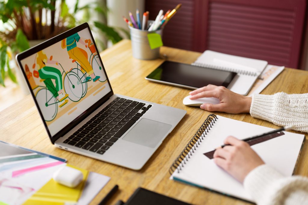 A desk showing a vibrant image of a bike on a laptop's screen, signifying creative work in progress