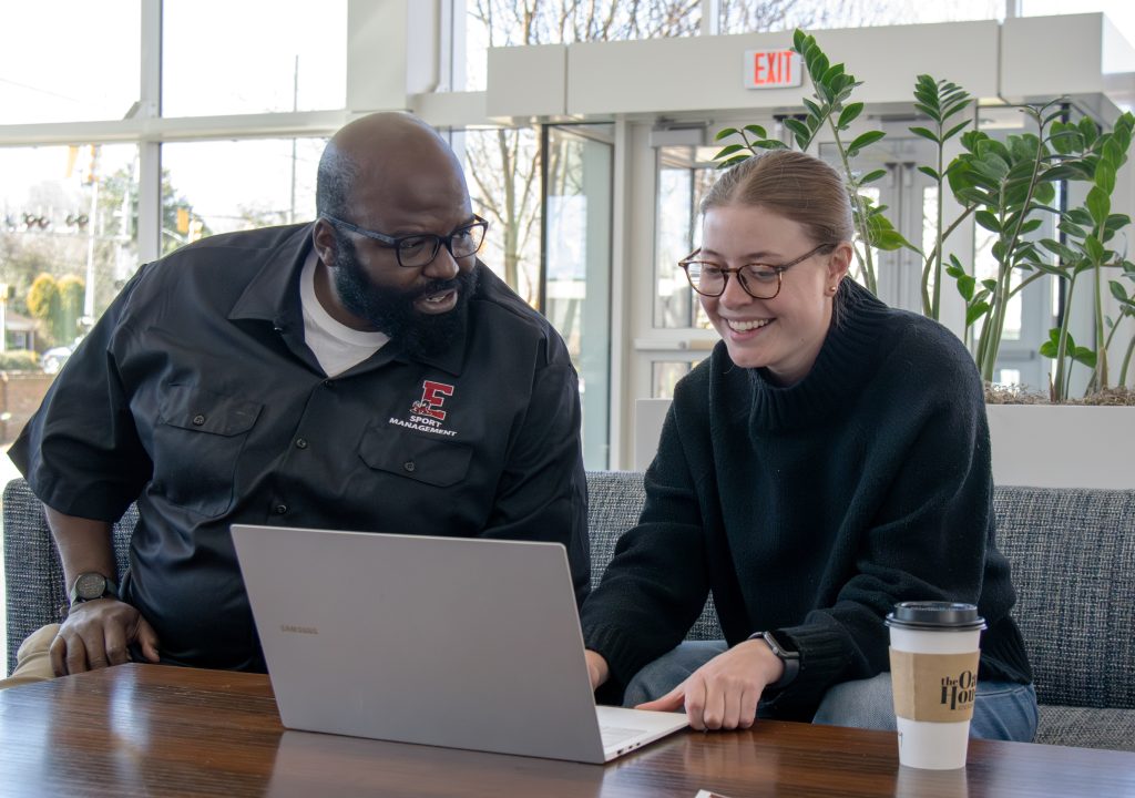 A photo of Assistant Professor Khirey Walker in conversation with an undergraduate researcher