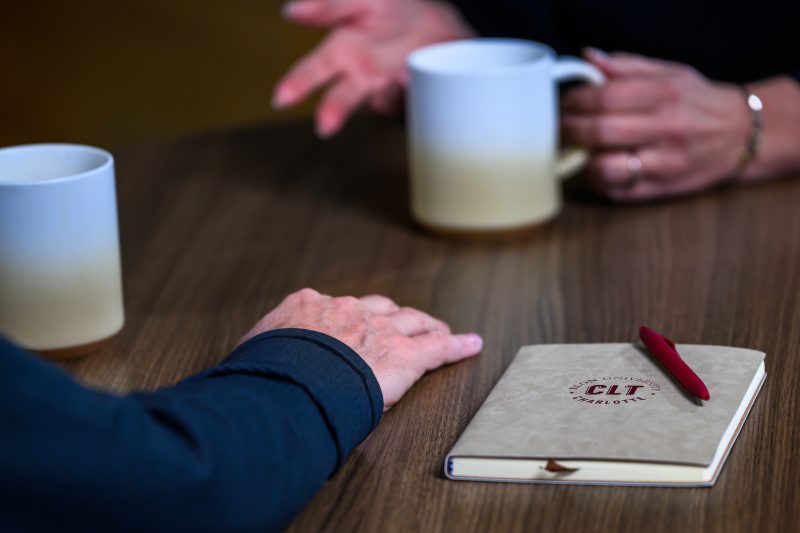 coffee mugs and a notebook on a table at the ������Ƶ Charlotte campus