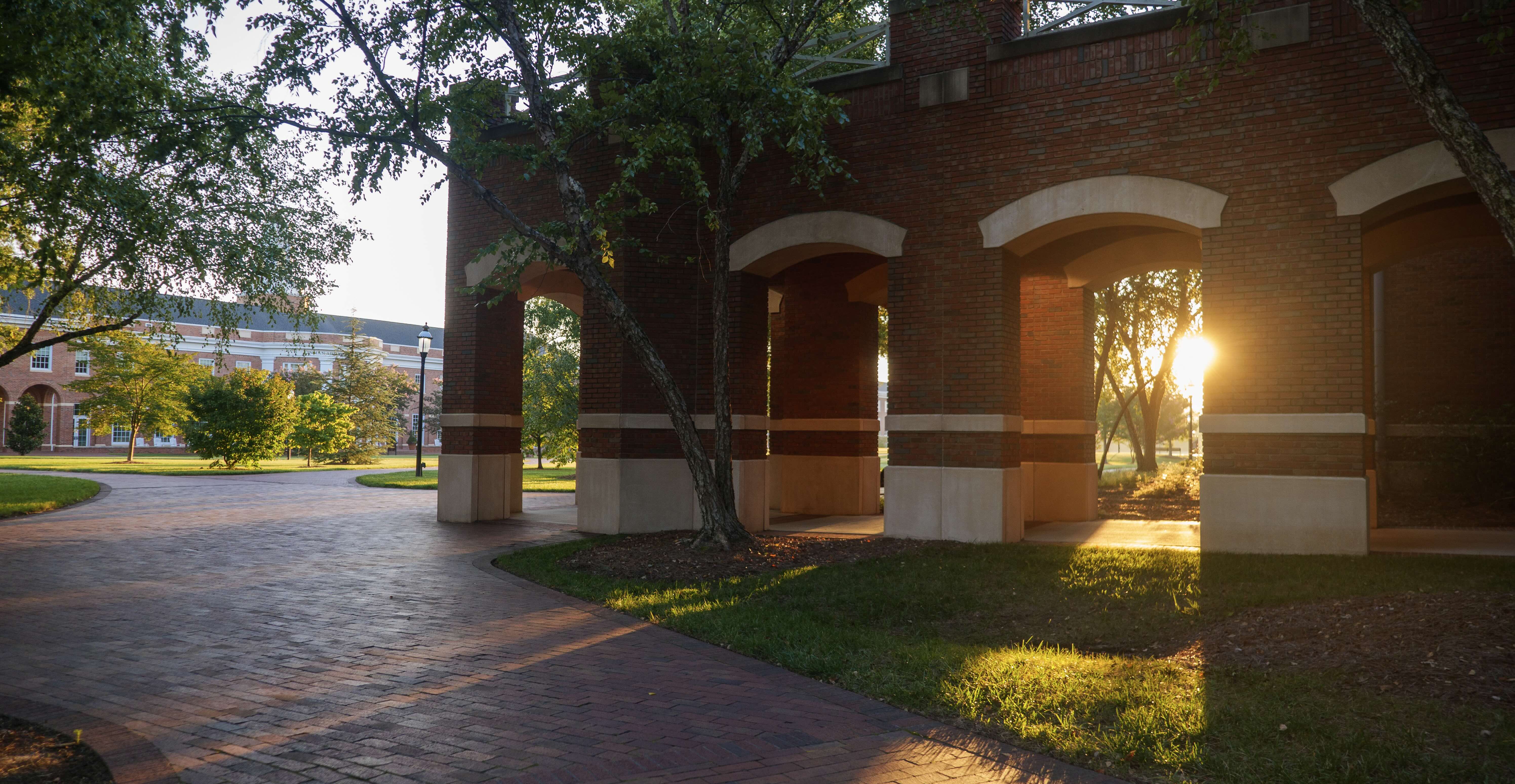 Brick colonnades with sun rising through the gaps