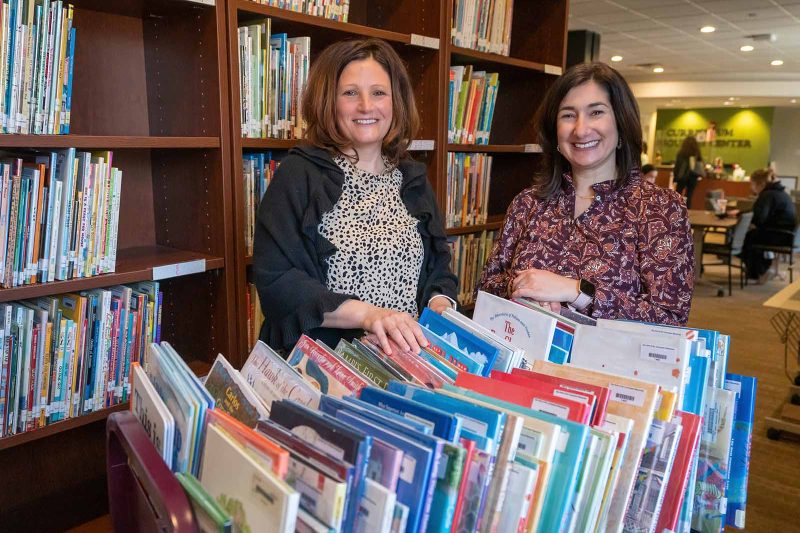 Products of Elon’s School of Education, Marna Winter ’98, left, and Erin Hone ’04 are teaching the next generation of elementary teachers at Elon. Winter and Hone are shown in the Curriculum Resource Center in the Mooney Building