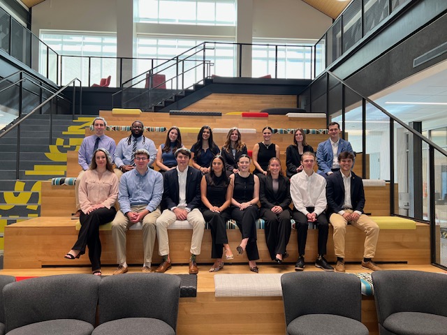 Group of engineering fellows dressed is business attire sitting in two rows.