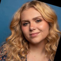 Close up photo of Kelli, she has blonde, curly hair.
