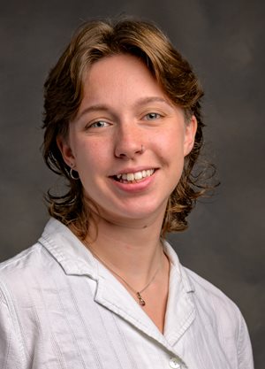 Photo of Samantha, she has short blonde hair and is wearing a white shirt.