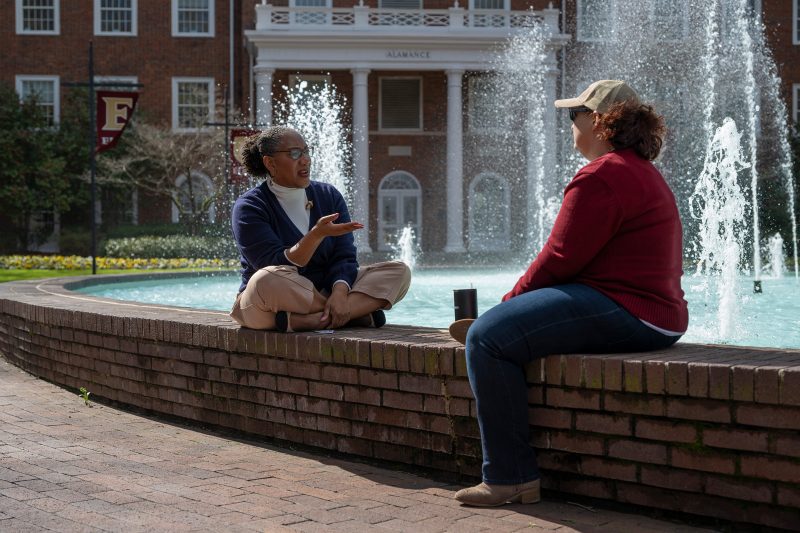 Naeemah Clark, Associate Provost for Academic Inclusive Excellence, talks with Staci Saltz, Cinema and Television Arts Department Chair, at Elon University's Fonville Fountain