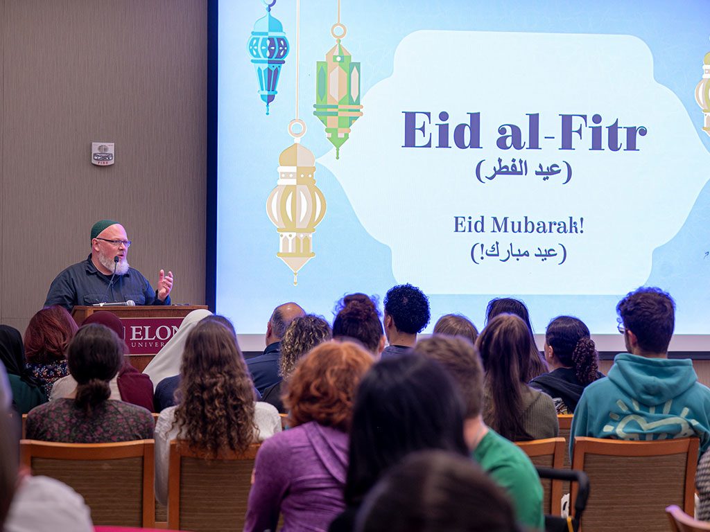 Photo of a speaker addressing attendees during an Eid al-Fitr celebration at Elon University