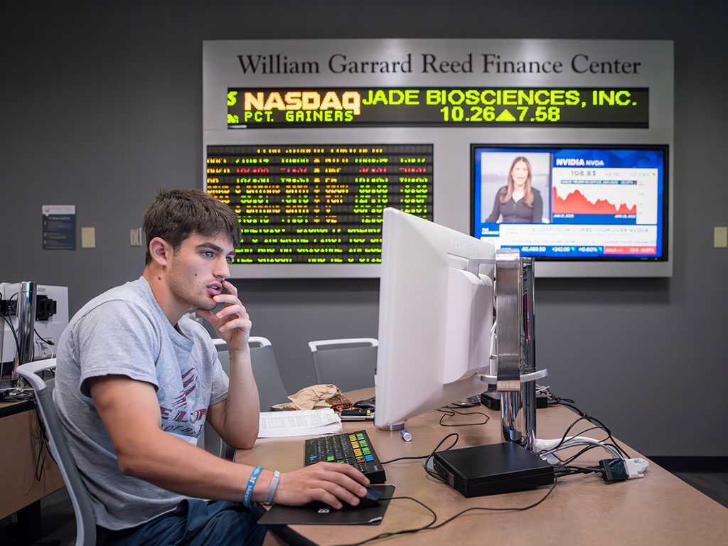 Photo of student working at a computer in the William Garrard Reed Finance Center while monitoring live market data