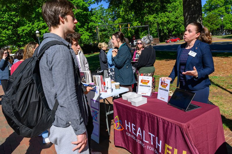 Anu Räisänen, Director of HealthEU Initiatives, speaking with students at a HealthEU "We Are Hiring" tabling event on Elon University's campus.