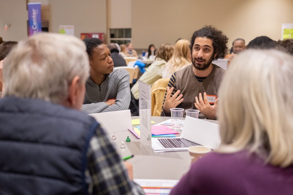 a participant in the power and place stories of alamance county event talks with others at their table